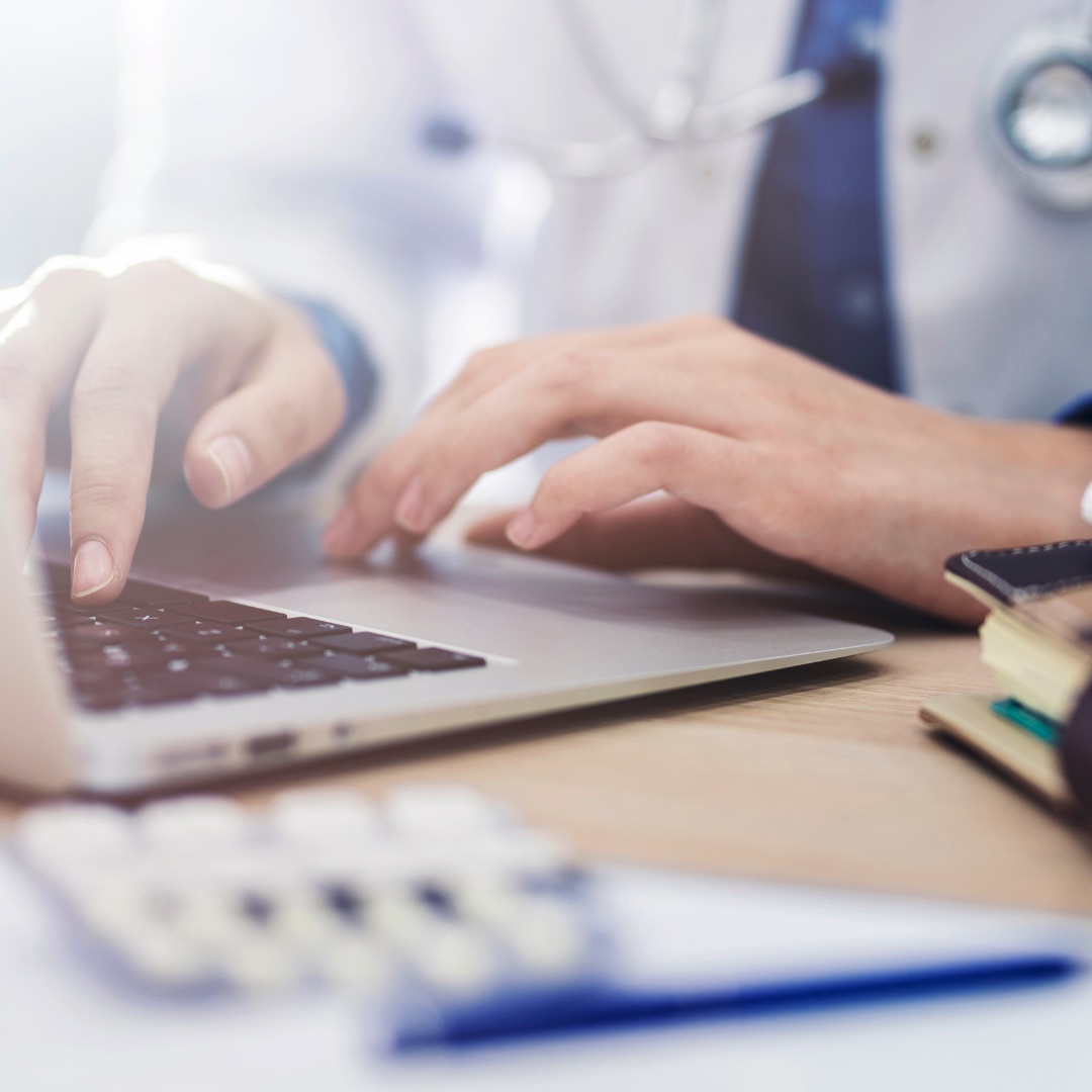 A healthcare professional working on a laptop
